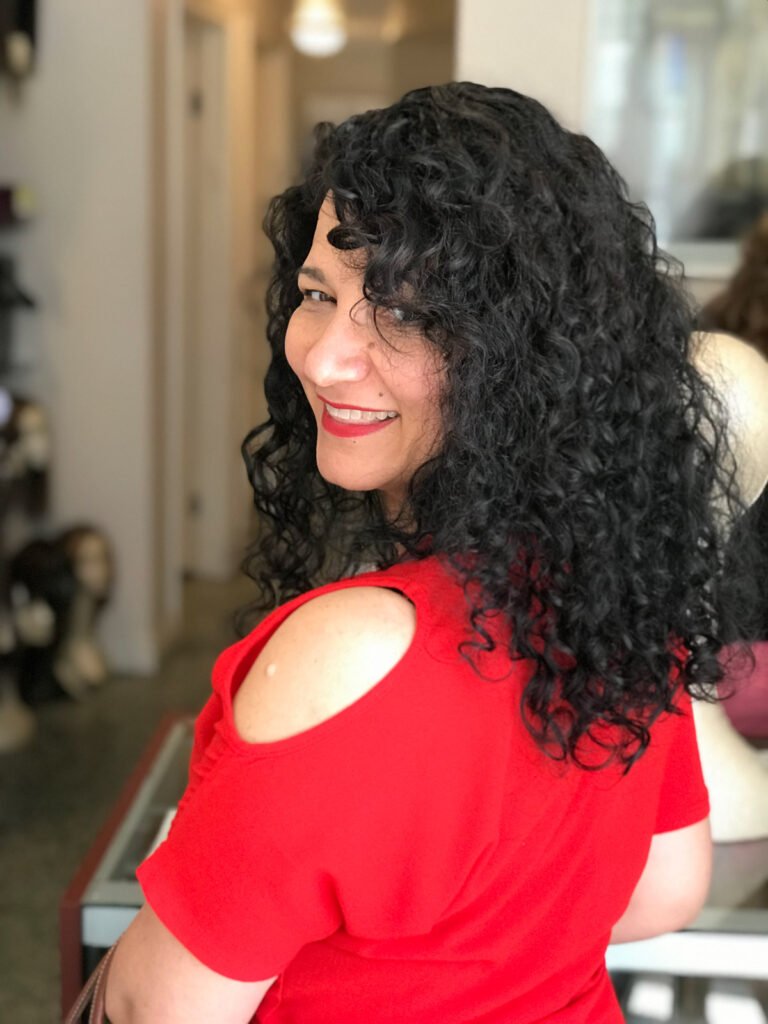 Woman wearing curly black human hair topper