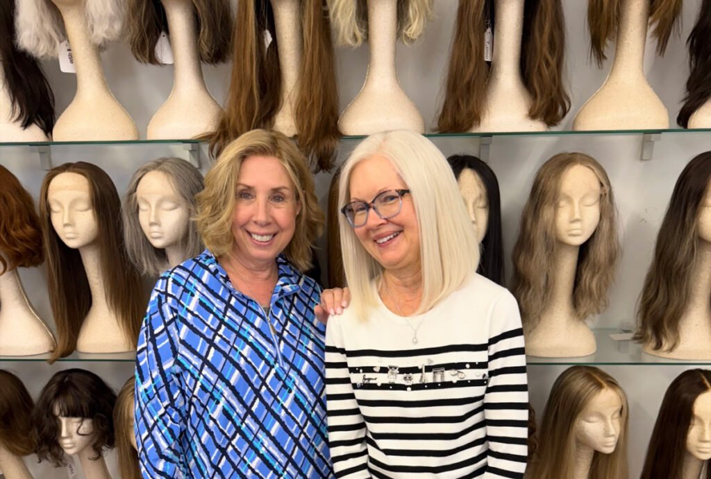 Two women wearing wigs in Paula's Miami wig shop