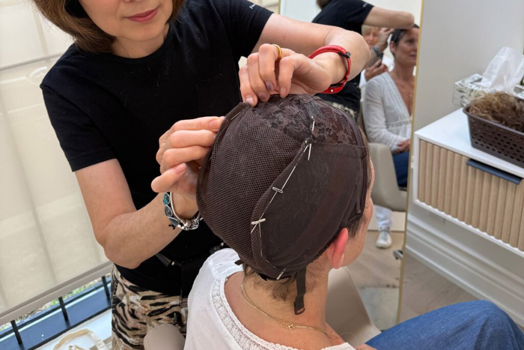 Wig stylist working on fitting woman to create custom human hair wig